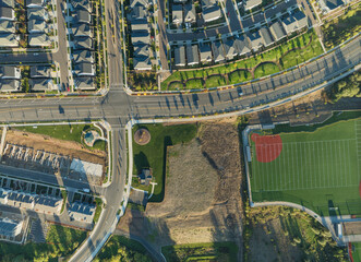 A view of a residential neighborhood with a park in the middle