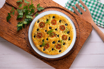 Italian focaccia with black olives and cherry tomatoes. Top view table with decorations.