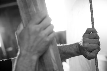 Black and white picture of Carpenter sanding wood using sandpape