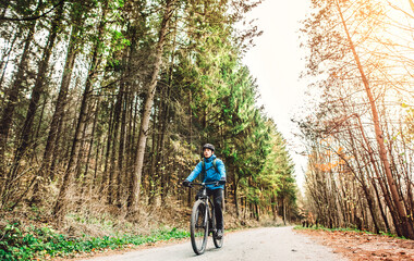Naklejka premium Active man on bike in the middle of beautiful nature, early autumn morning. Concept of healthy lifestyle.