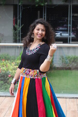 woman in stylish and modern navratri look with heavy neckless and multi color chaniya - lehengha - ghaghra for garba and dandiya in Navratri. Happy smiling gujarati indian girl in traditional outfit