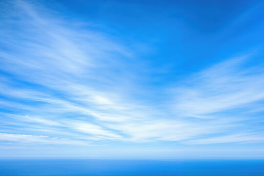 Cirrus cloudscape with motion blur effect above ocean horizon