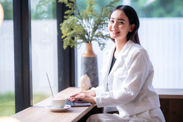 asian freelance people business female talking making using casual working with laptop computer for browsing internet, chatting and blogging and smartphone,notebook in coffee shop.