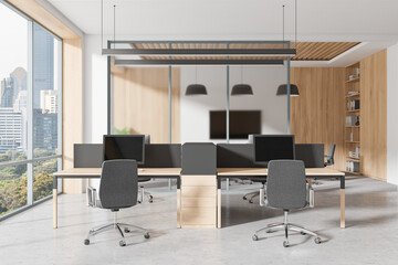 A modern open space office with wooden interior, featuring desks, chairs, and computers. Large windows provide a city view, creating a business concept. 3D Rendering