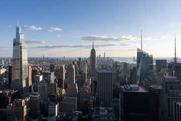 Aerial view of New York City skyline with Empire State Building and skyscrapers in Manhattan at sunset.