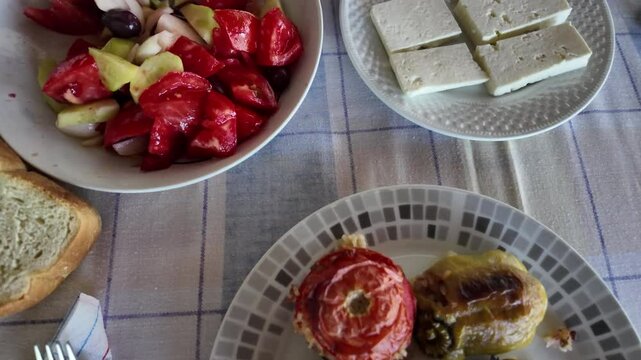 View of a delicious salad, with tomatoes, olives, onions, cucumber, feta cheese and stuffed peppers and tomatoes in slow motion