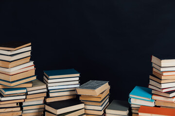 Stacks of educational books for studying in the university library as a black background