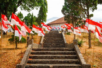 The red and white flag is flying on one of the historic buildings in Kuningan
