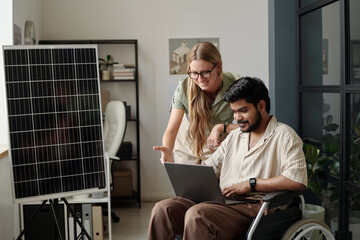 Confident female engineer and her male colleague with disability discussing presentation points