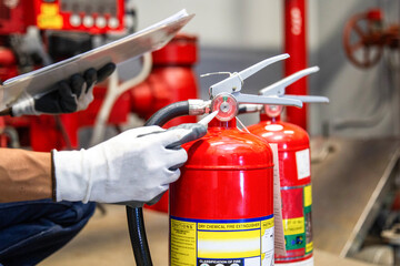 Engineer are checking and inspection a fire extinguishers tank in the fire control room for safety...