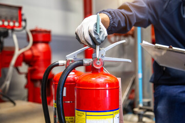 Engineer are checking and inspection a fire extinguishers tank in the fire control room for safety training and fire prevention.