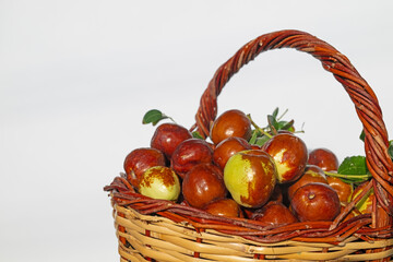 Ripe brown jujube fruits in a basket, isolated on a white background. Delicious, ripe berries in a basket. Close-up.