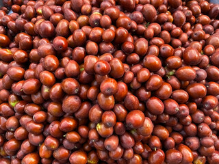 Ripe brown jujube berries on the market stall. Delicious, ripe, organic fruit. Close-up.