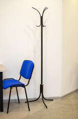 A blue chair sits next to a black metal pole