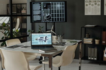 Part of modern office with workplace of architect working over new project using laptop and mockups