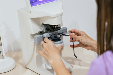 Optician measuring eyeglasses prescription on lensmeter