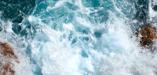 Fototapeta premium The force of a waterfall crashing into a river below, creating waves and white water