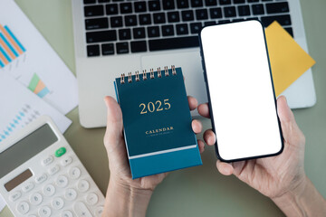 Top view of woman using smartphone blank screen on desk