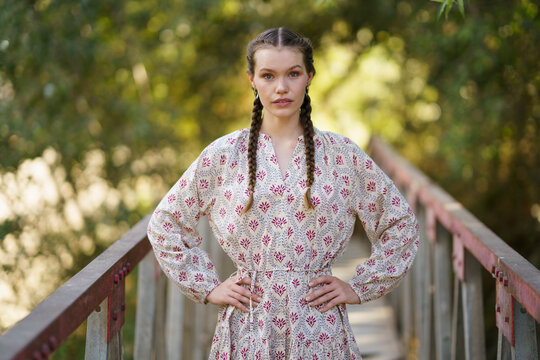 Young woman with hands on hip standing on bridge