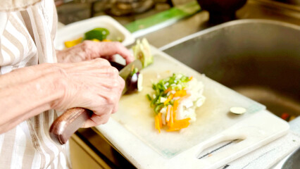 野菜を切る高齢女性の手元