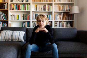 Portrait of mature woman sitting on couch at home