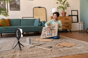Influencer with environment placard vlogging through smart phone