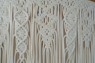 Detailed close-up of handcrafted macramé wall hanging showcasing intricate knots and patterns in natural fibers