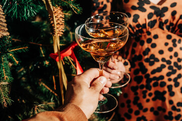 Couple toasting wineglasses near Christmas tree at party