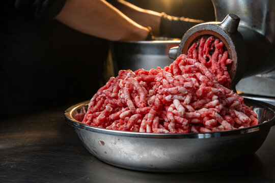 Process of fresh meat grinding in the kitchen with modern electric grinder, top down