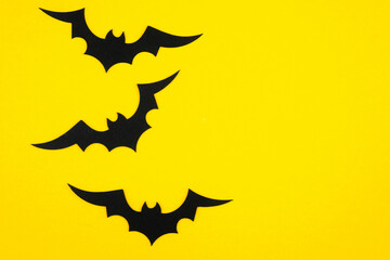 Bats flying against a vibrant yellow background in an artistic display of motion and form