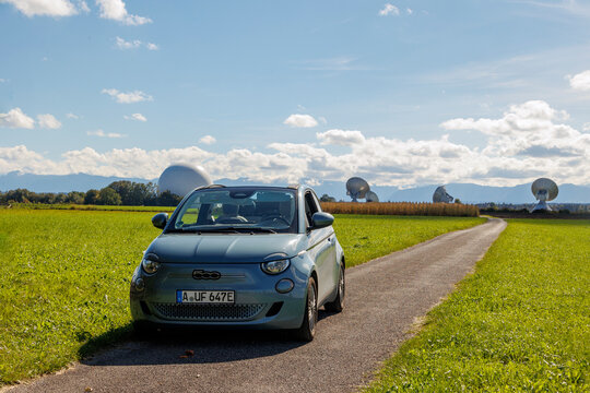 blue Fiat 500e convertible with open sunroof in front of the radome in Raisting am Ammersee under blue sky in Germany, Raisting 29.9.2024