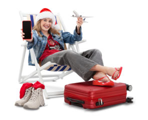 Christmas Holiday travel and vacation concept, tourist woman in travel attire wears a santa hat, on deck chair with trolley suitcases, showing smartphone and model airplane. Flight and travel booking.