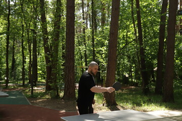 Fototapeta premium Ping pong player, involved in a table tennis competition, hitting the ball during an intense match.
