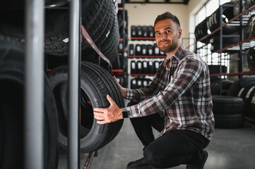 A young man buys new tires for his car