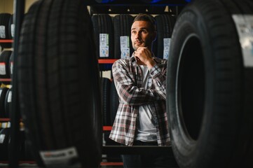 customer tire fitting in the car service, auto mechanic checks the tire and rubber tread for safety
