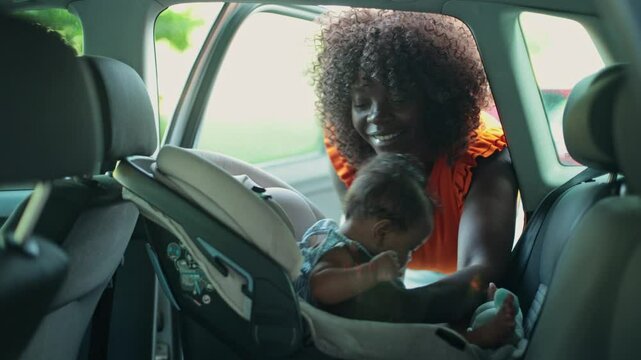 Mother Unbuckling Baby from Car Seat to Take Out of the Car