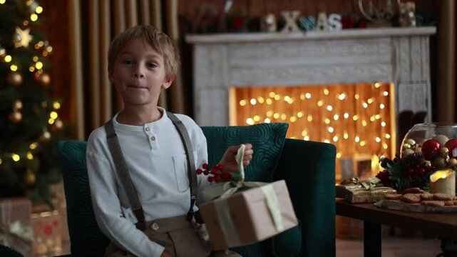 Sweet blond child, cute boy, playing with christmas toys on Christmas, beautifully decorated home for Christmas, cosy place