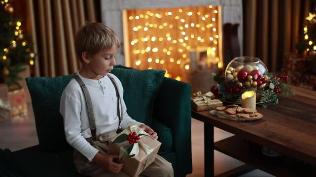 Sweet blond child, cute boy, playing with christmas toys on Christmas, beautifully decorated home for Christmas, cosy place