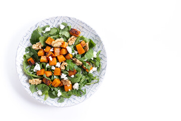 Pumpkin salad with arugula, walnuts and feta cheese isolated on white background. Top view. Copy space