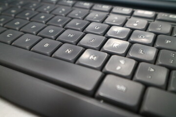 A close up photo of a grey and white office computer keyboard.