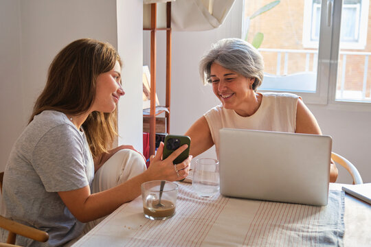 Mother and daughter enjoying a chatty moment with gadgets