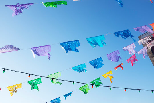 Vibrant Mexican festival flags against a clear blue sky