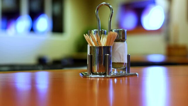 Salt shaker and pepper with toothpicks on the table.