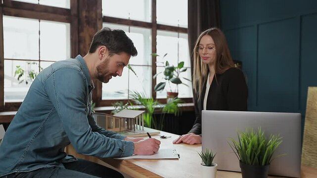 Man sign mortgage contract, put signature on sale purchase rental agreement, handshaking realtor at meeting with estate agent, satisfied customers buy property, get keys of new home.
