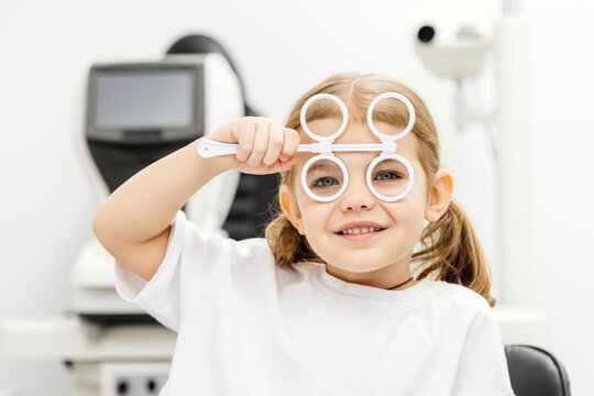 Diagnosis and improvement of vision in modern ophthalmology in young patients. The girl playfully engages in prevention, emphasizing the importance of a comfortable approach to treatment.