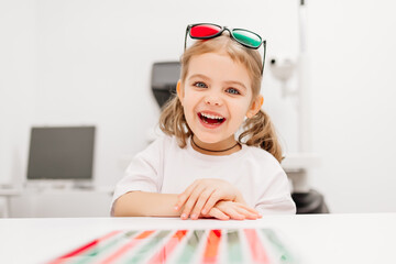Orthoptic therapy. The concept of vision restoration and training. A cheerful smiling girl wearing...