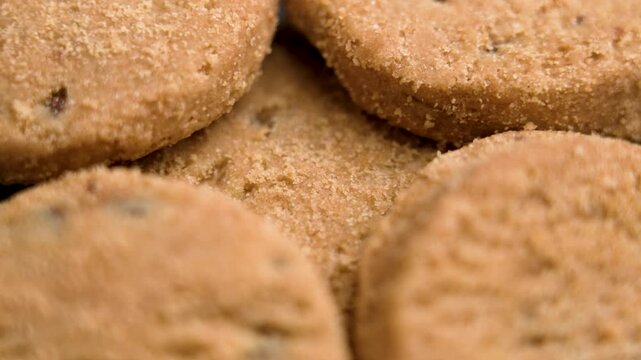 Freshly baked biscuits with golden brown crumbly texture and chocolate pieces. Macro. Rotation