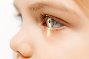 Close-up of a little girl with deep eyes undergoing vision diagnostics using a slit lamp in an ophthalmology clinic. A perfect moment highlighting the importance of caring for children's vision.