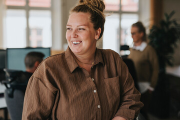 Happy businesswoman with hair bun looking away in office