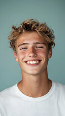 front portrait of a young Caucasian man, smiling, centered, short messy blonde hair, light skin tone, plain light blue background